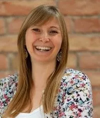 Tamara Frühwirth lachend vor einer Ziegelwand